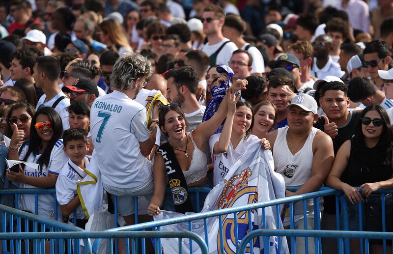 Real Madrid supporters celebrate while awaiting the team's arrival at Cibeles square. Getty
