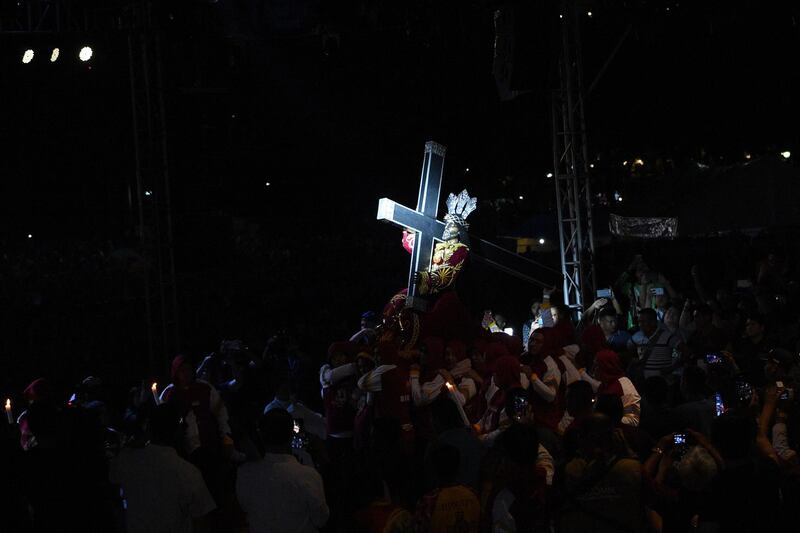 A light illuminates the statue of the Black Nazarene as it is carried on a carriage at the start of an annual religious procession. AFP