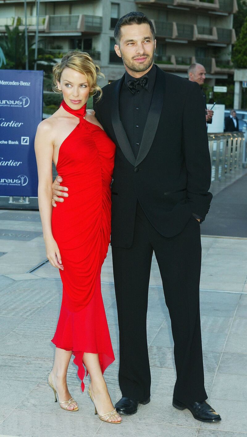 Kylie Minogue, in a red halterneck dress, and Olivier Martinez attend the Laureus World Sports Awards on May 20, 2003 at the Grimaldi Forum in Monaco.