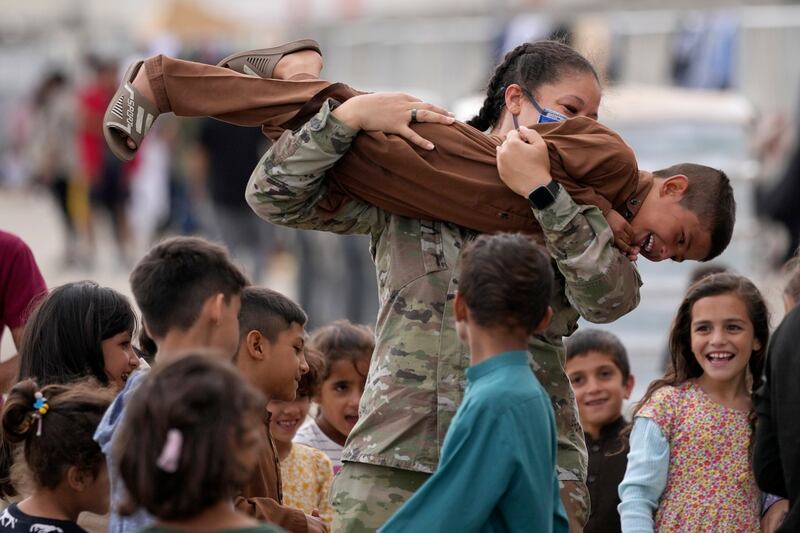 A US soldier plays with Afghan children at the Ramstein US Air Base, Germany. AP Photo