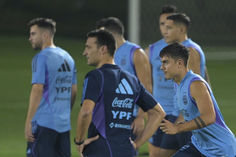 Argentina's forward Paulo Dybala next to coach Lionel Scaloni during a training session at Qatar University. AFP