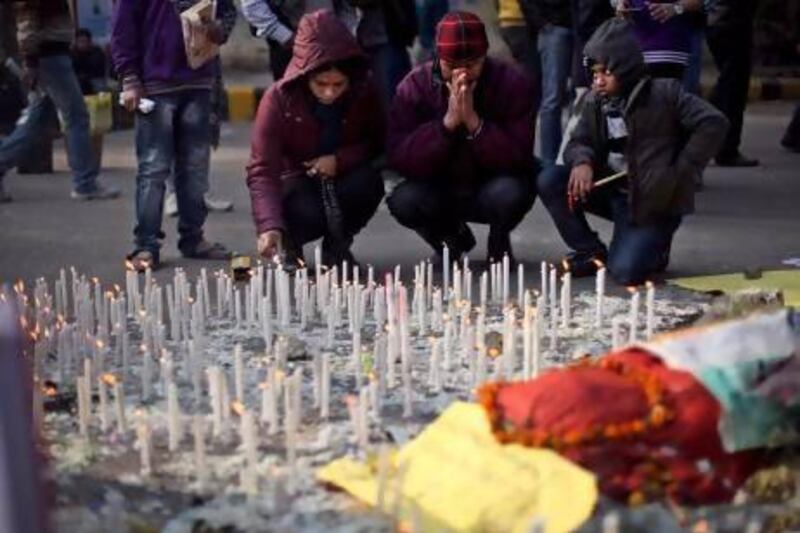An Indian family lights candles in memory of a gang-rape victim in New Delhi yesterday as the country still churns after her death.