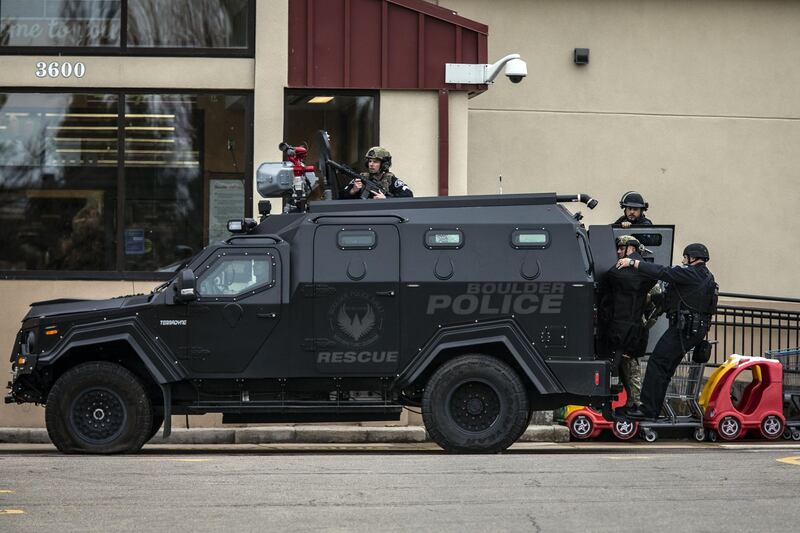 SWAT teams advance through a parking lot as a gunman opened fire at a King Sooper's grocery store. AFP