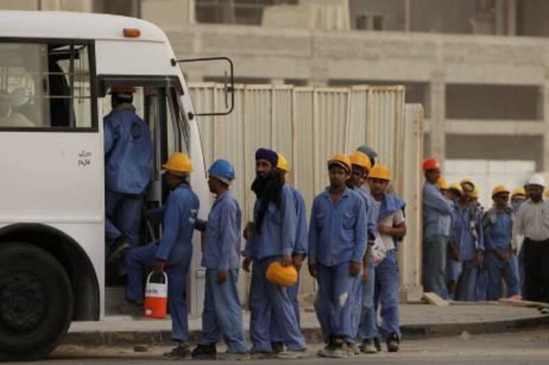 MUSSAFAH (EAST), ABU DHABI, UNITED ARAB EMIRATES - July 8, 2009: Construction workers wait to board busses from a construction site in Mohammed Bin Zayed City. 
( Ryan Carter / The National ) *** Local Caption ***  RC002-Labour.JPG