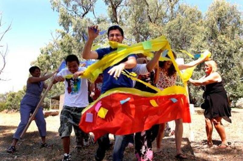 Youngsters run through a banner bearing words of tolerance and unity in the Multifaith Future Leaders forum at Kyneton.