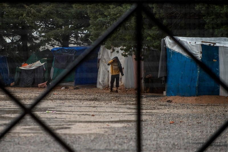 A migrant walks inside the migrant camp at Malakasa village, north of Athens, on April 5, 2020. Officials in Greece on April 5 placed a second migrant camp near Athens under lockdown after an Afghan resident tested positive for the Covid-19, the novel coronavirus, the migration ministry said. / AFP / Angelos Tzortzinis
