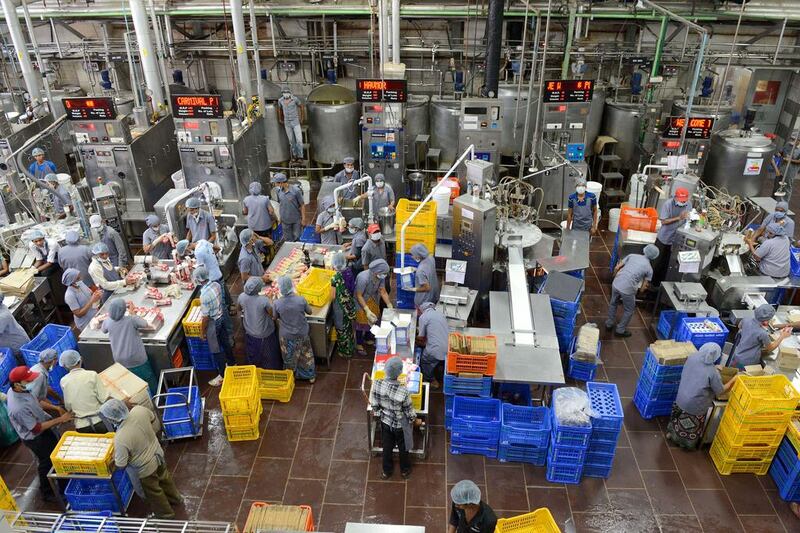 Factory workers are pictured on their production lines at the Havmor Ice Cream plant at Naroda near Ahmedabad in India. Industry estimates project India's ice cream industry to grow to 70 billion rupees by 2018 from 45bn rupees in 2013. Sam Panthaky / AFP