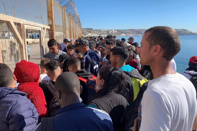 A group of people try to cross the border fence separating Morocco and Ceuta. EPA