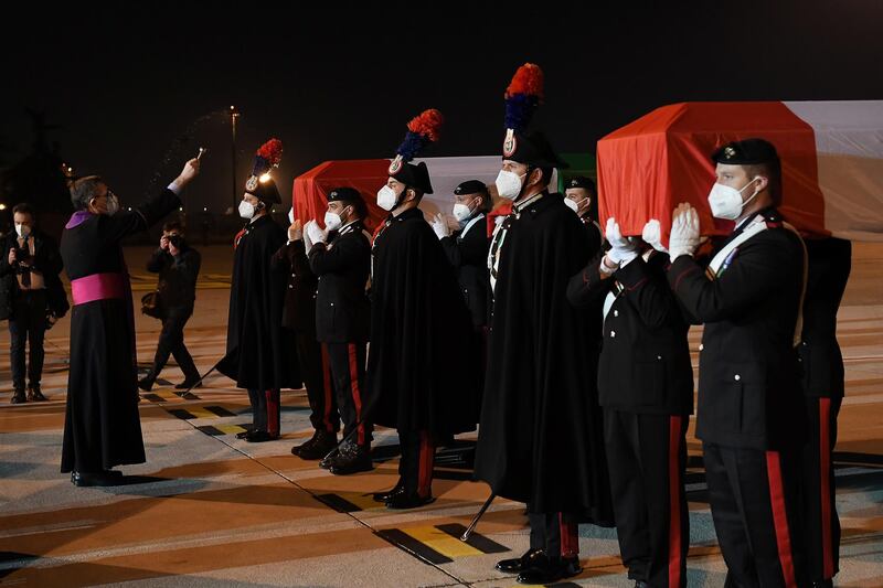 A priest blesses the coffins carrying the bodies of the ambassador and his bodyguard. Reuters