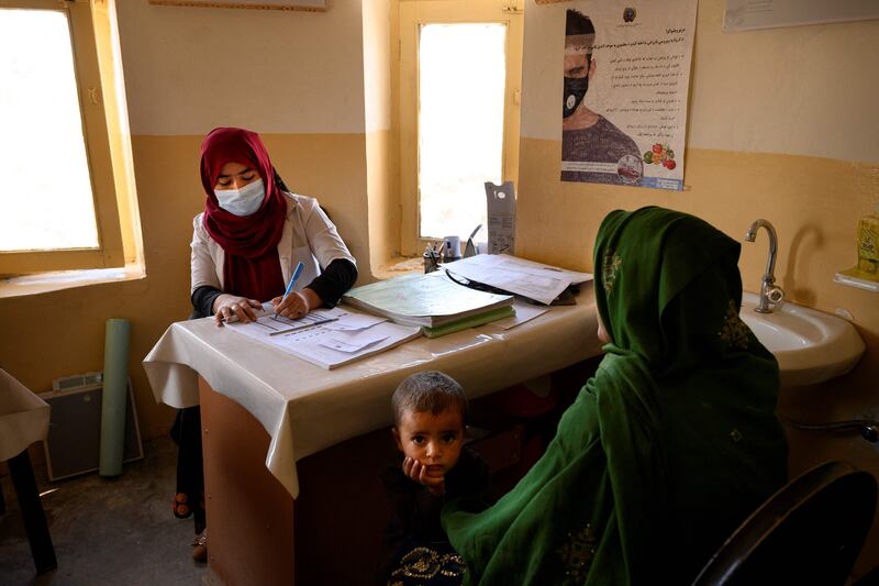 Nurse Husna (L) records the personal details of Khorma, who doesn’t know her exact age, for an antenatal care visit at a government-run maternity in Dand.