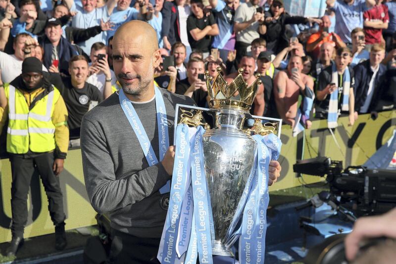 BRIGHTON, ENGLAND - MAY 12: Pep Guardiola the head coach / manager of Manchester City shows the Premier League Trophy to fans of Manchester City during the celebrations of becoming 2019 Champions after the Premier League match between Brighton & Hove Albion and Manchester City at American Express Community Stadium on May 12, 2019 in Brighton, United Kingdom. (Photo by Matthew Ashton - AMA/Getty Images)