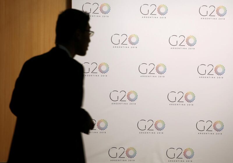 FILE PHOTO: A man stands next to a board with the G20 Meeting of Finance Ministers logo in Buenos Aires, Argentina, March 19, 2018. REUTERS/Marcos Brindicci/File Photo