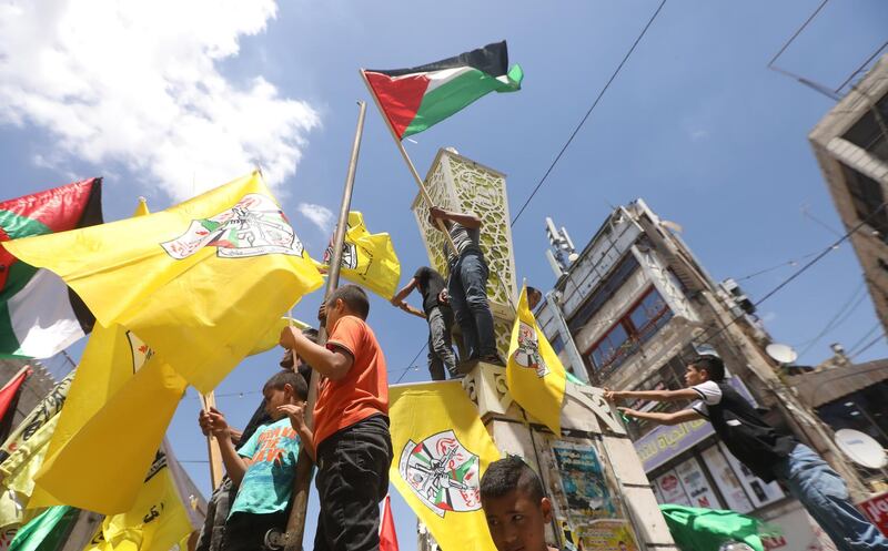 epa09219427 Palestinian protesters wave flags during a rally to celebrate the cease fire reached between Hamas and Israel, after an 11 day war, in the West Bank city of Jenin, 22 May 2021.  EPA/ALAA BADARNEH