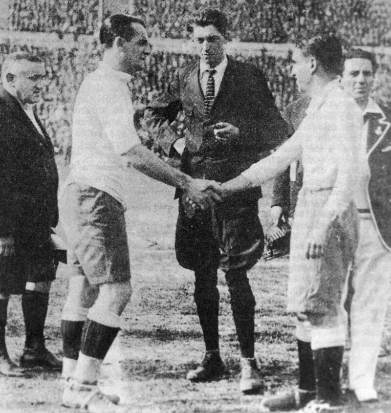 Uruguay captain Jose Nazassi, left, shakes hands with his Argentinian counterpart 'Nolo' Fereyra before the final of the first World Cup competition in Montevideo, which Uruguay won . With them is referee John Langenus and linesmen Saucedo and Henry Christophe. Photo: Getty Images