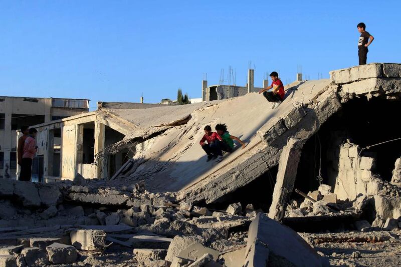 Syrian children slide down rubble of destroyed a building in the rebel-held city of Deraa on September 12, 2016, as a ceasefire brokered by Russia and the US went into effect across Syria. Mohamad Abazeed / AFP