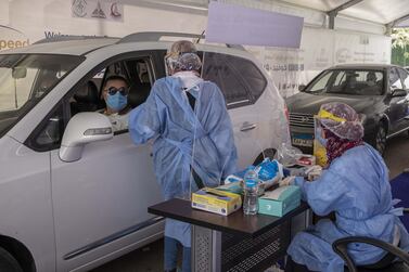 A health worker prepares to take swab samples to test for the coronavirus at a drive-through screening centre in Cairo, Egypt. AP