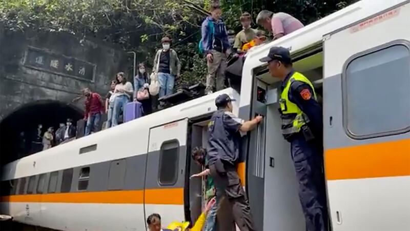 In this image made from a video released by hsnews.com.tw, passengers are helped to climb out of a derailed train in Hualien County in eastern Taiwan. The train partially derailed along Taiwan’s east coast Friday. AP