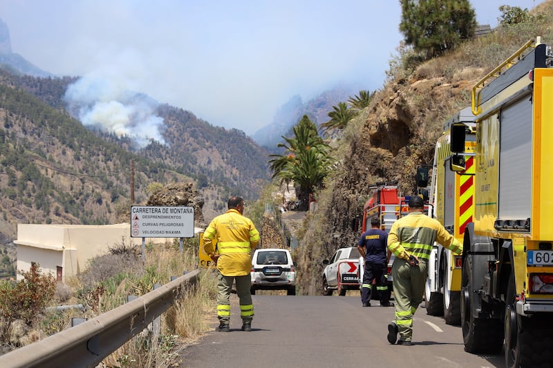 Firefighters watch as a forest fire reignites in Spain's Caldera de Taburiente national park. EPA