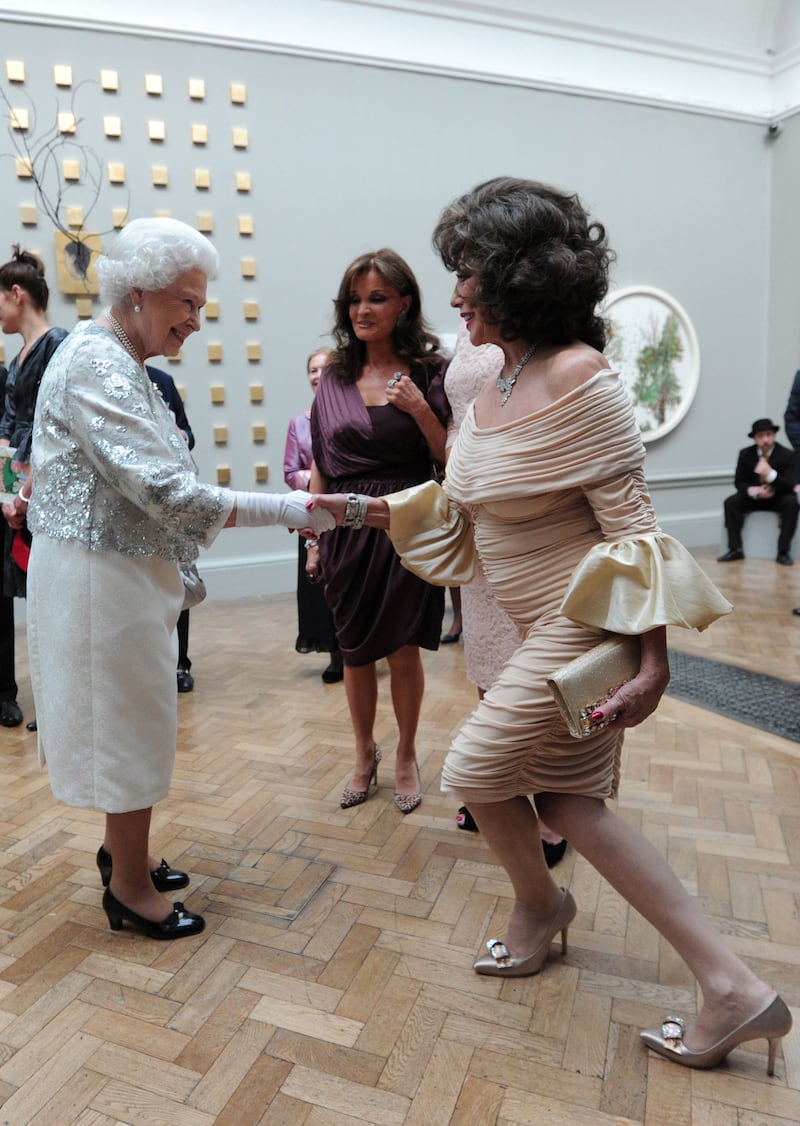 Queen Elizabeth II with Joan Collins at a special Celebration of the Arts event at the Royal Academy of Arts on May 23, 2012, in London, England. Getty Images