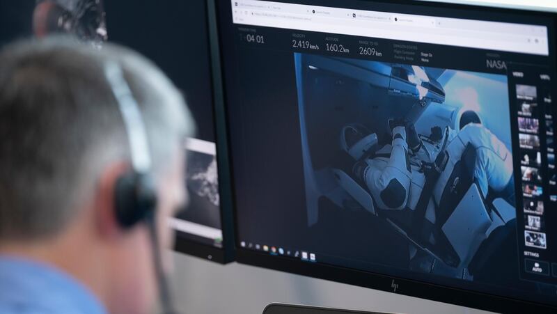 In this image released by Nasa, astronauts Robert Behnken and Douglas Hurley are displayed on a monitor as they sit inside the Dragon crew capsule during the successful launch of a SpaceX Falcon 9 rocket at the Launch Control Centre at Kennedy Space Centre in Cape Canaveral, Florida.  AP