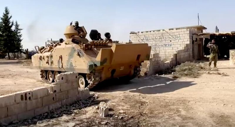 A Syrian rebel tank carrying soldiers leaves their base near Tal Abyad, Syria, in this screen grab taken from video. Reuters
