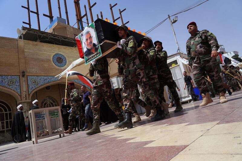 Members of Iraq's Shiite Muslim Hashed al-Shaabi (Popular Mobilisation units) paramilitary force carry the coffin of their comrade Kazem Mohsen, known by his nom de guerre Abu Ali al-Dabi, during his funeral procession in the central shrine city of Najaf south of the Iraqi capital Baghdad on August 26, 2019.  The Iraqi fighter was killed in a drone attack late yesterday near the western border with Syria, in the latest in a string of suspicious explosions and drone sightings at Hashed bases across Iraq but the first time that the group specifically blamed Israel.  / AFP / Hashed al-Shaabi Media / Haidar HAMDANI
