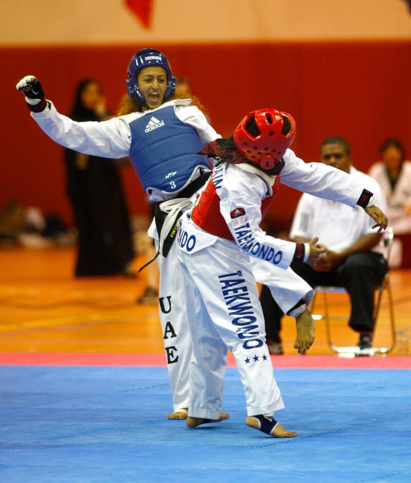 Abu Dhabi, UAE, Sept. 24, 2010, Women's Taekwondo Championship-(Blue Head Gear) Basma Essa reacts to her head kick to  Zawan Zaid (Red Head Gear)  during the elimination rounds of the Women's Taekwondo Championship. . Mike Young / The National  