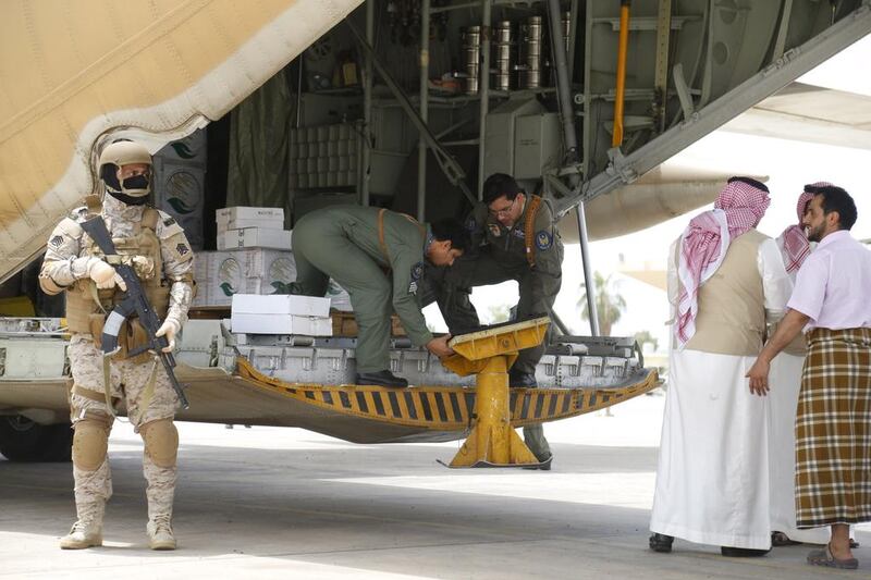 A Saudi soldier stands guard as servicemen on a military cargo plane unload aid at Aden's international airport on July 24, 2015. Faisal Al Nasser/Reuters
