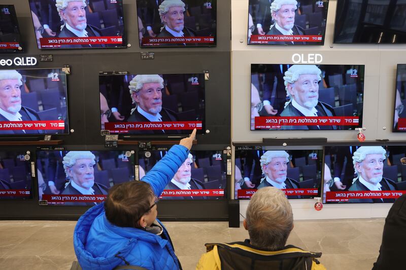 Israelis watch a live stream of the court session at a TV shop in Jerusalem. EPA