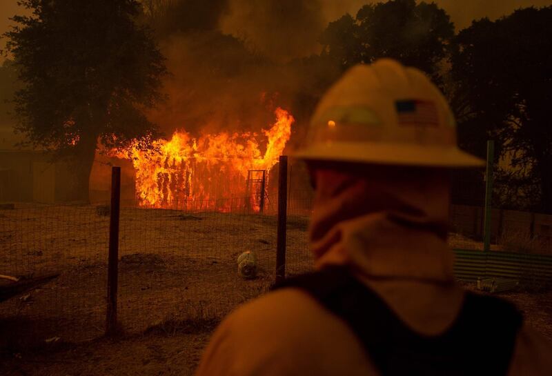 A firefighter watches as a building burns during the Mendocino Complex fire in Lakeport, California. AFP PHOTO / JOSH EDELSON