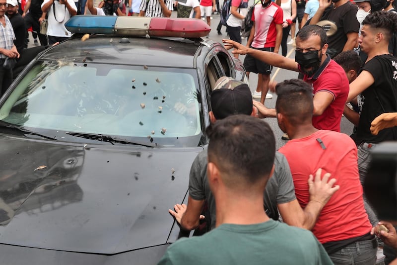 Anti-government protesters throw stones at a police car near Parliament Square on Sept 1. AP