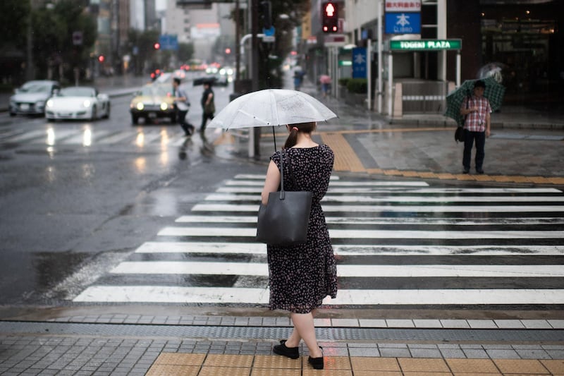 A woman protects herself from the rain with an umbrella in Tokyo.  AFP / Martin BUREAU