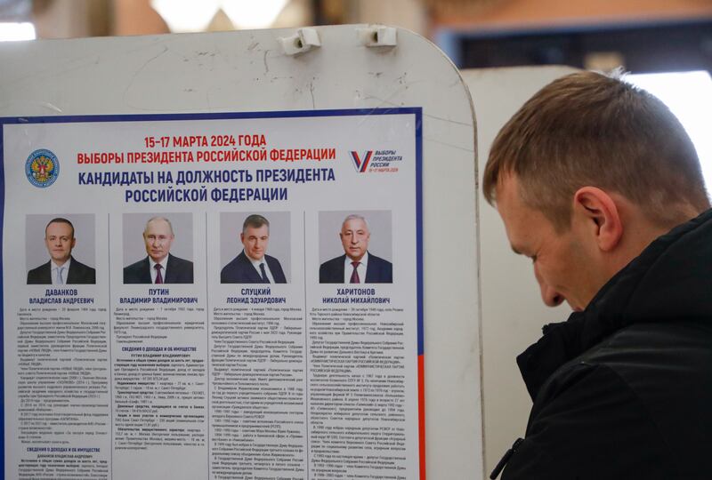 A poster shows the candidates in Russia's presidential elections at a polling station in Moscow. EPA