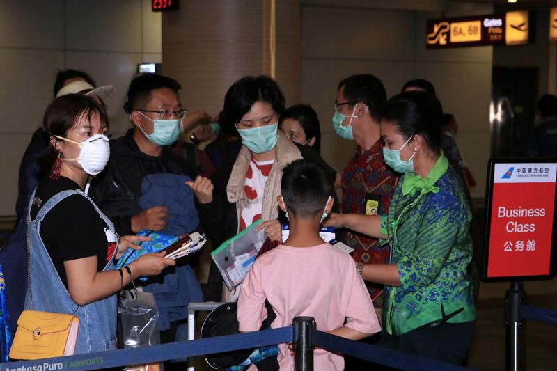 Airport staff at Bali airport check the tickets of passengers of a China Southern Airlines flight to Guangzhou, China, a day before the Indonesian government temporarily stopped flights to and from China. Reuters
