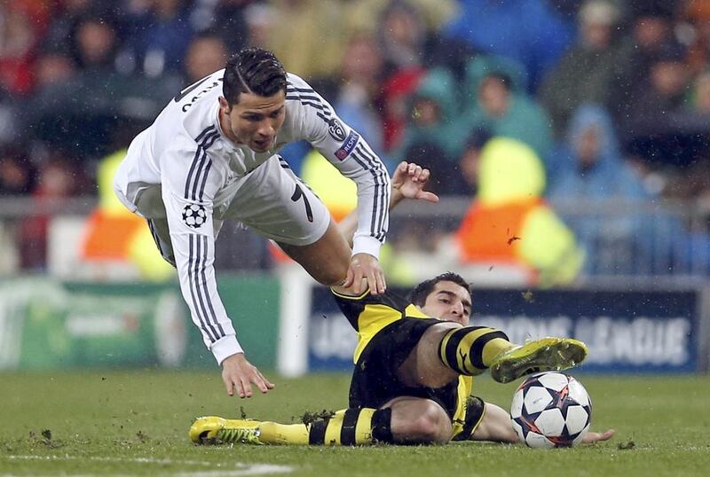 Cristiano Ronaldo, left, of Real Madrid falls over Henrikh Mkhitaryan of Borussia Dortmund during their Uefa Champions League quarter-final first leg match at Santiago Bernabeu stadium in Madrid on April 2, 2014. Javier Barbancho / Reuters