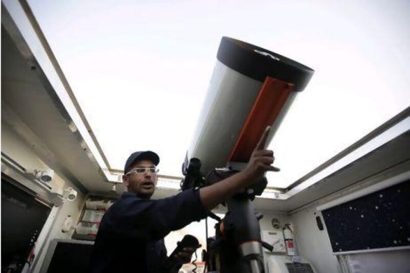 Astronomer Nezar Hezam Sallam aligns his telescope on the eve of the start of Ramadan. Sammy Dallal / The National