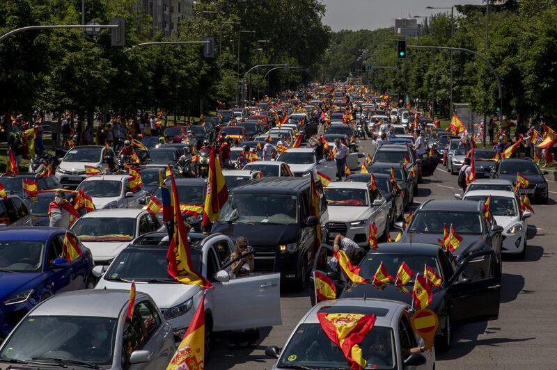 MADRID, SPAIN - MAY 23: People hold Spanish flags as they take part on an in-vehicle protest against the Spanish government on May 23, 2020 in Madrid, Spain. Far right wing VOX party has called for in-vehicle protests across Spain against the Spanish government's handling of the Covid-19 pandemic. Spain has imposed some of the tightest restrictions across the world to contain the spread of the virus, but measures are now easing. Most of the Spanish population supports the lockdown according to a survey. (Photo by Pablo Blazquez Dominguez/Getty Images) *** BESTPIX ***