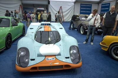 Attendees view a 1970 Porsche AG 917k race vehicle, formerly driven by actor Steve McQueen in the movie "Le Mans", at the Gooding and Company auction during the 2017 Pebble Beach Concours d'Elegance in Pebble Beach, California, U.S., on Friday, Aug. 18, 2017. Official estimates for the Pebble Beach auctions this week have set sales totals at $290 million, down 14 percent since 2016. The downshift in overall sales isn't for lack of funds among buyers, but rather a decrease that comes because classic cars of this caliber are a finite resource. Photographer: David Paul Morris/Bloomberg