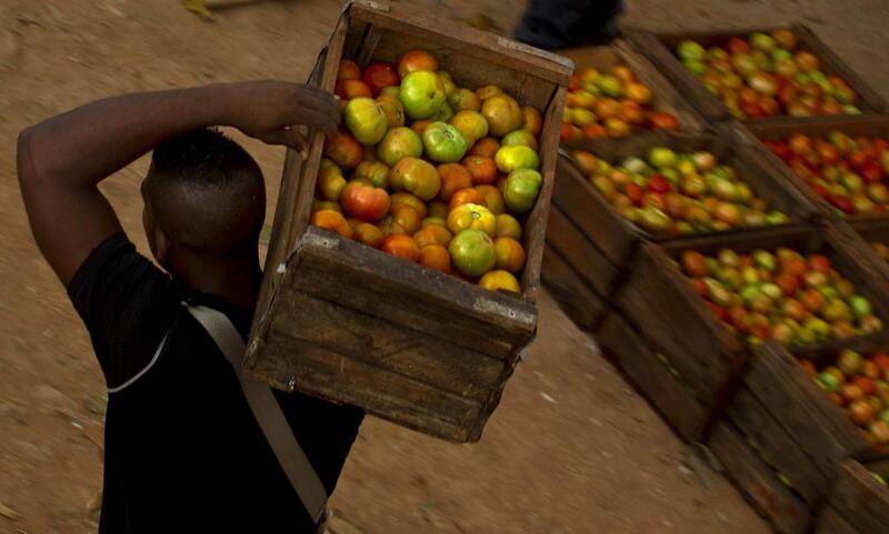 A man carries a box of tomatoes at the 114th Street Market on the outskirts of Havana, Cub. Ramon Espinosa / AP Photo