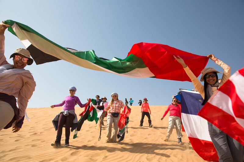 Participants wave the flags of their home countries during the five-day adventure. Courtesy Women’s Heritage Walk