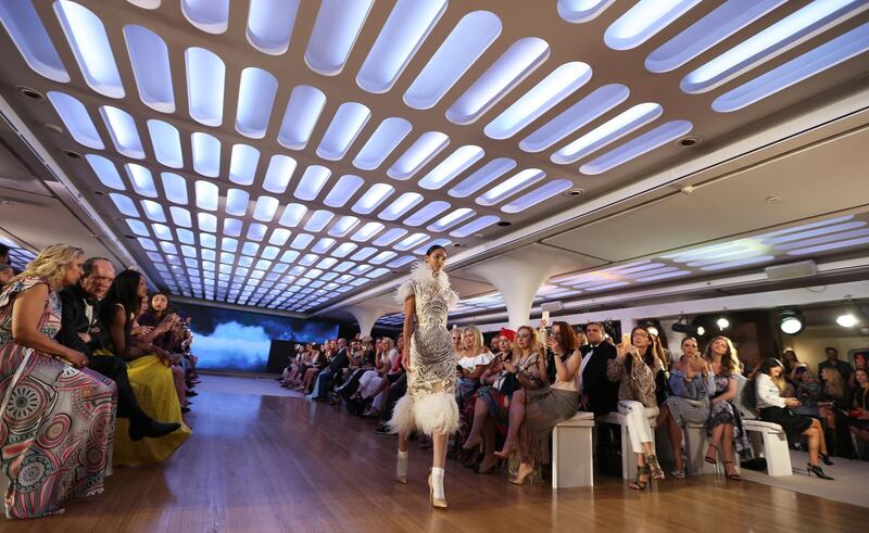 epa06723902 A model displays a creation from the collection of Amato Couture during the first floating fashion week experience of the Arab Fashion Week held at the Queen Elizabeth II Ship naval hotel at Port Rashid in Dubai, United Arab Emirates, 09 May 2018.  EPA/ALI HAIDER