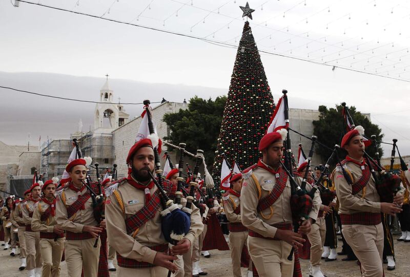 Palestinian Christian scouts perform at the Manger Square outside the Church of the Nativity as people gather for Christmas celebrations in the town of Bethlehem in the Israeli-occupied West Bank, on December 24, 2017. / AFP PHOTO / HAZEM BADER