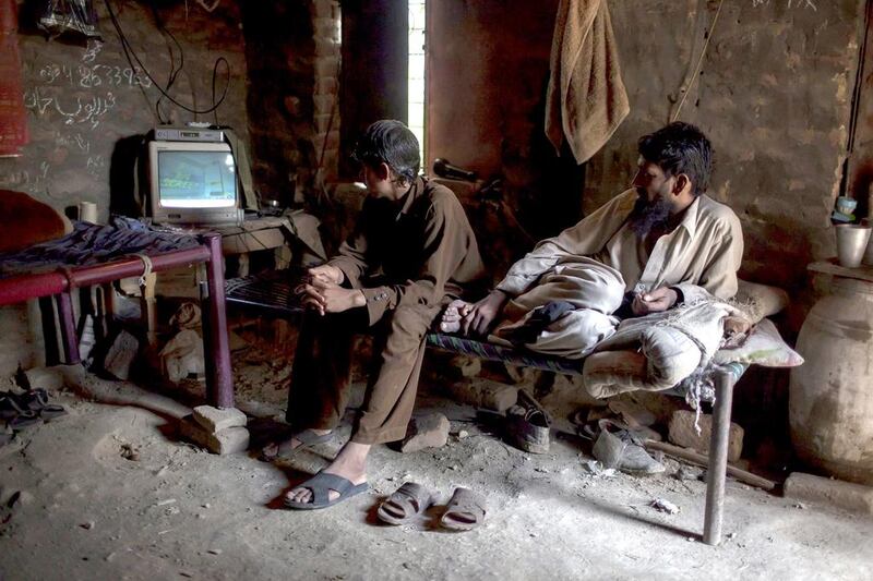 Miners on a break watch TV in a room at a coal field in Choa Saidan Shah, Punjab. Sara Farid / Reuters