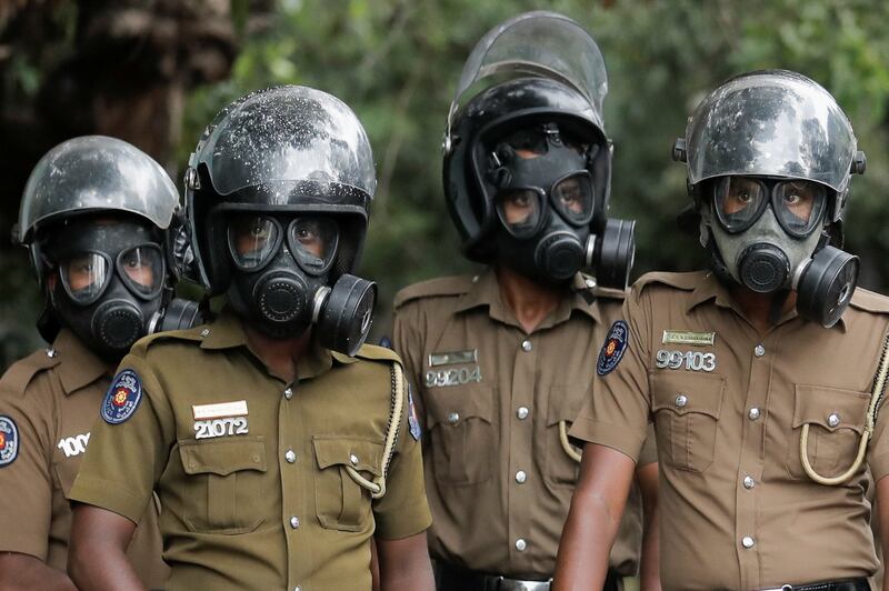 Sri Lankan police officers wearing gas masks stand guard on a road leading to the parliament building, after the government of President Gotabaya Rajapaksa lost its majority, amid the country's economic crisis, in the capital Colombo. Reuters