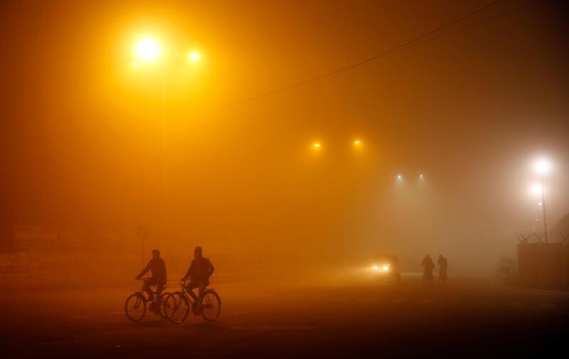 Indian men pedal bicycles through heavy fog in Lucknow, India. Rajesh Kumar Singh / AP Photo