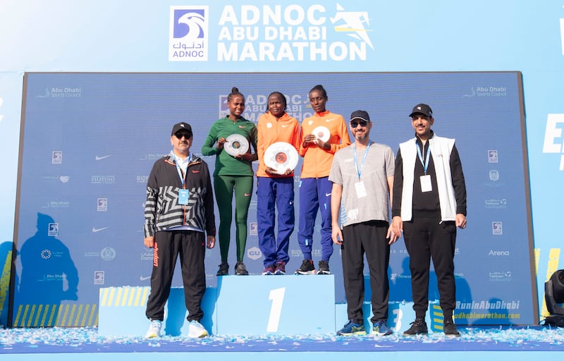 Adnoc Abu Dhabi Marathon women's race winner Brigid Kosgei, centre, with second-placed Hawi Feysa Gejia, left, and Sintayehu Dessi. All photos Ruel Pableo for The National