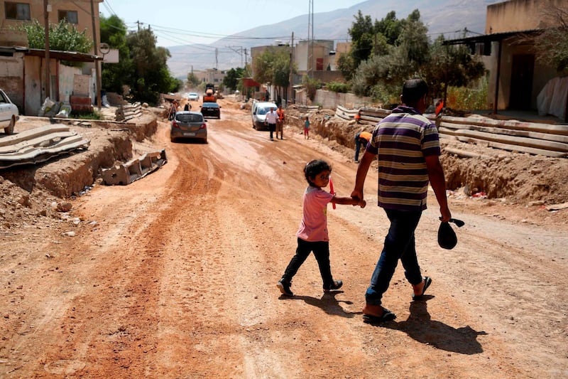 A father and his daughter cross a street in the occupied West Bank. AFP