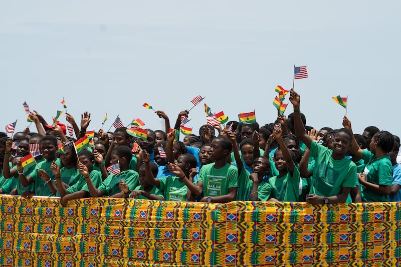 Schoolchildren wave Ghanaian and US flags to welcome Ms Harris. Getty Images