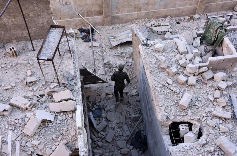 A member of Syrian pro-government forces inspects a building in Masaken Hanano, eastern Aleppo, a day after they took the neighbourhood from rebel fighters. George Ourfalian / AFP Photo