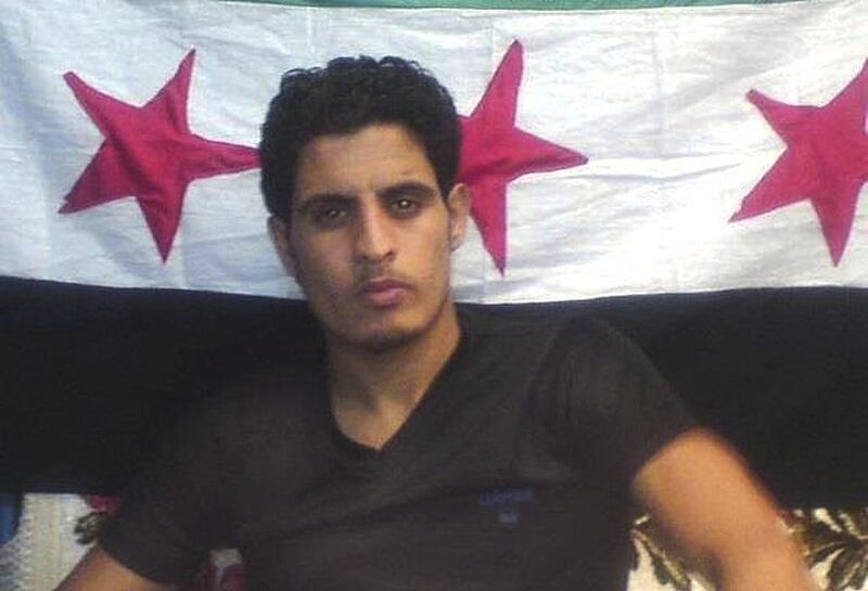 Abdelbasset Saroot, former Syria international goalkeeper, is seen in front of opposition flag in this undated photograph received by Reuters in May 2012. Reuters Photo / May 2, 2012